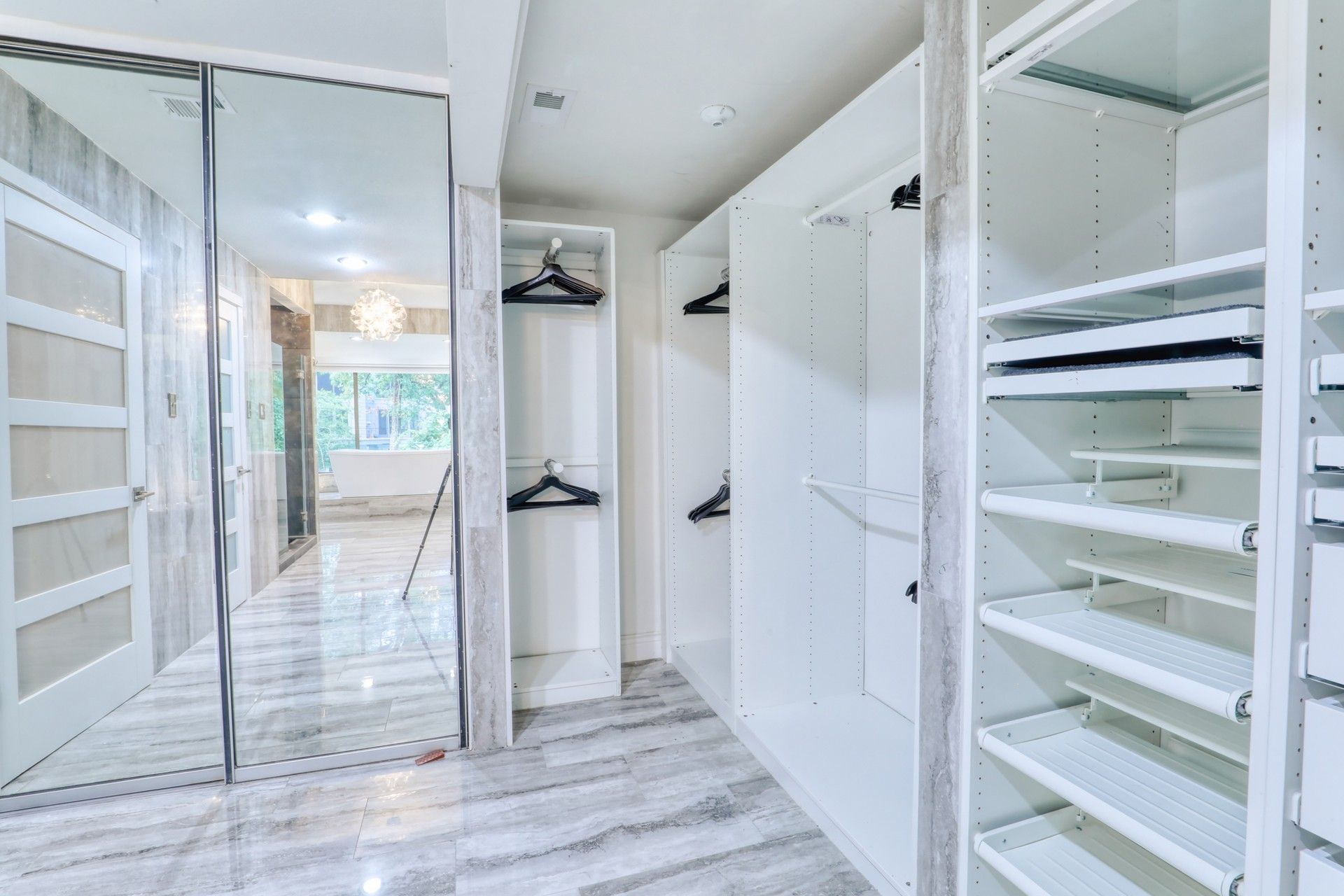 Walk-in closet with mirrored doors and built-in shelving