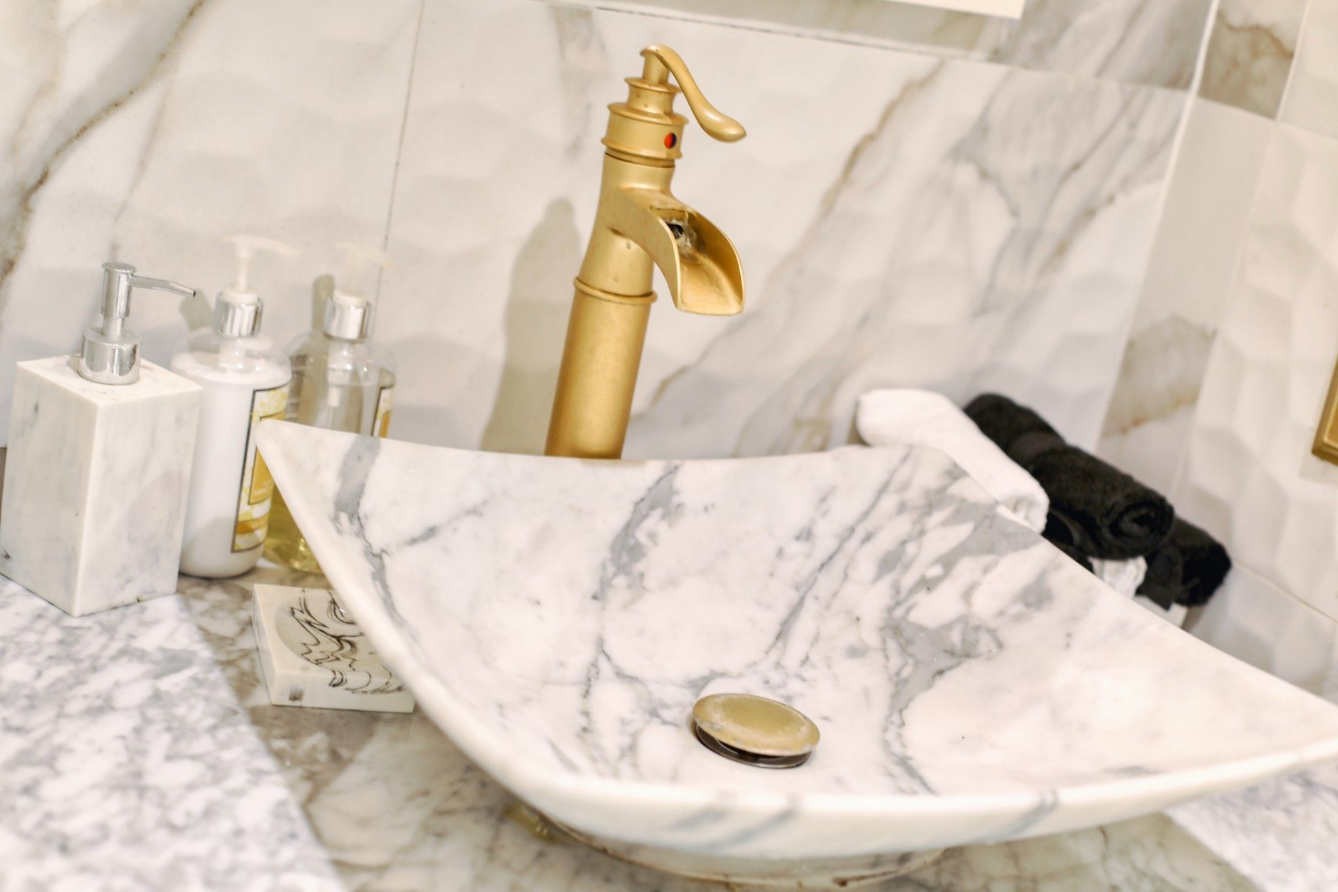 Marble vessel sink with brushed-gold faucet
