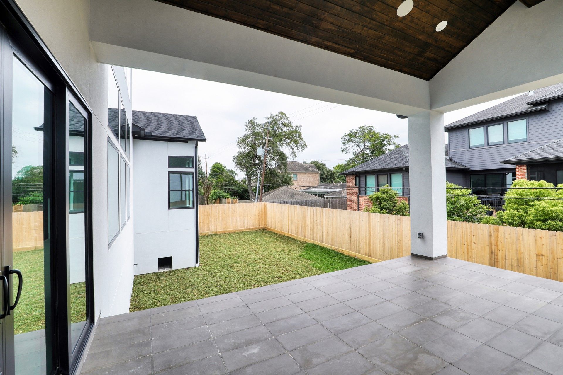 Covered patio overlooking a fenced backyard