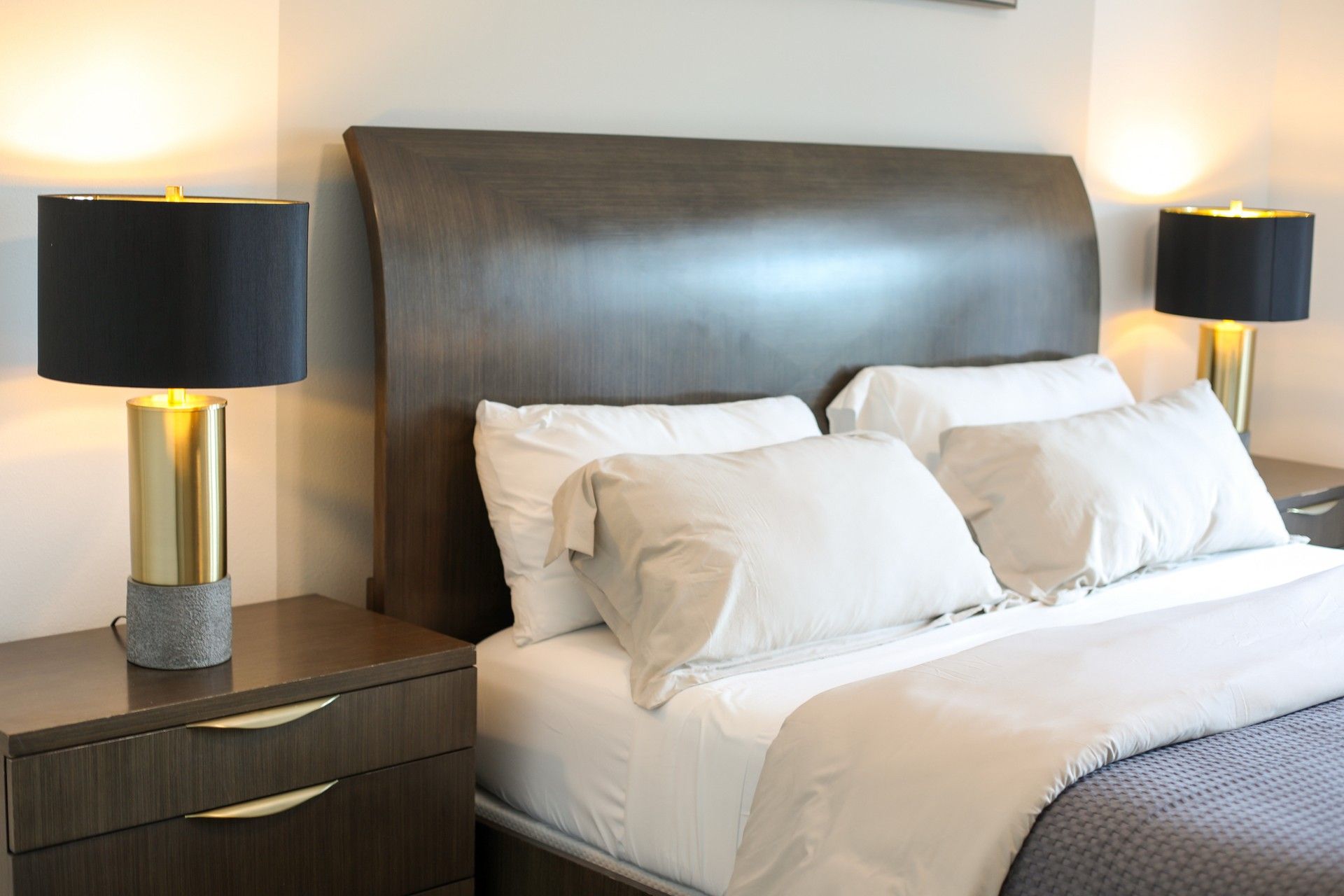 Bedroom with upholstered headboard and gold lamps